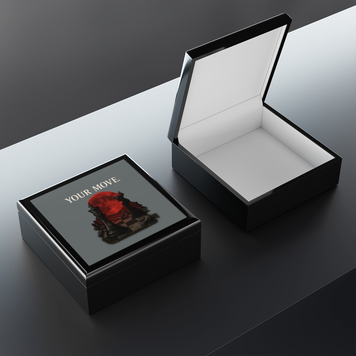 Black jewelry box with 'Your Move' design on a reflective surface