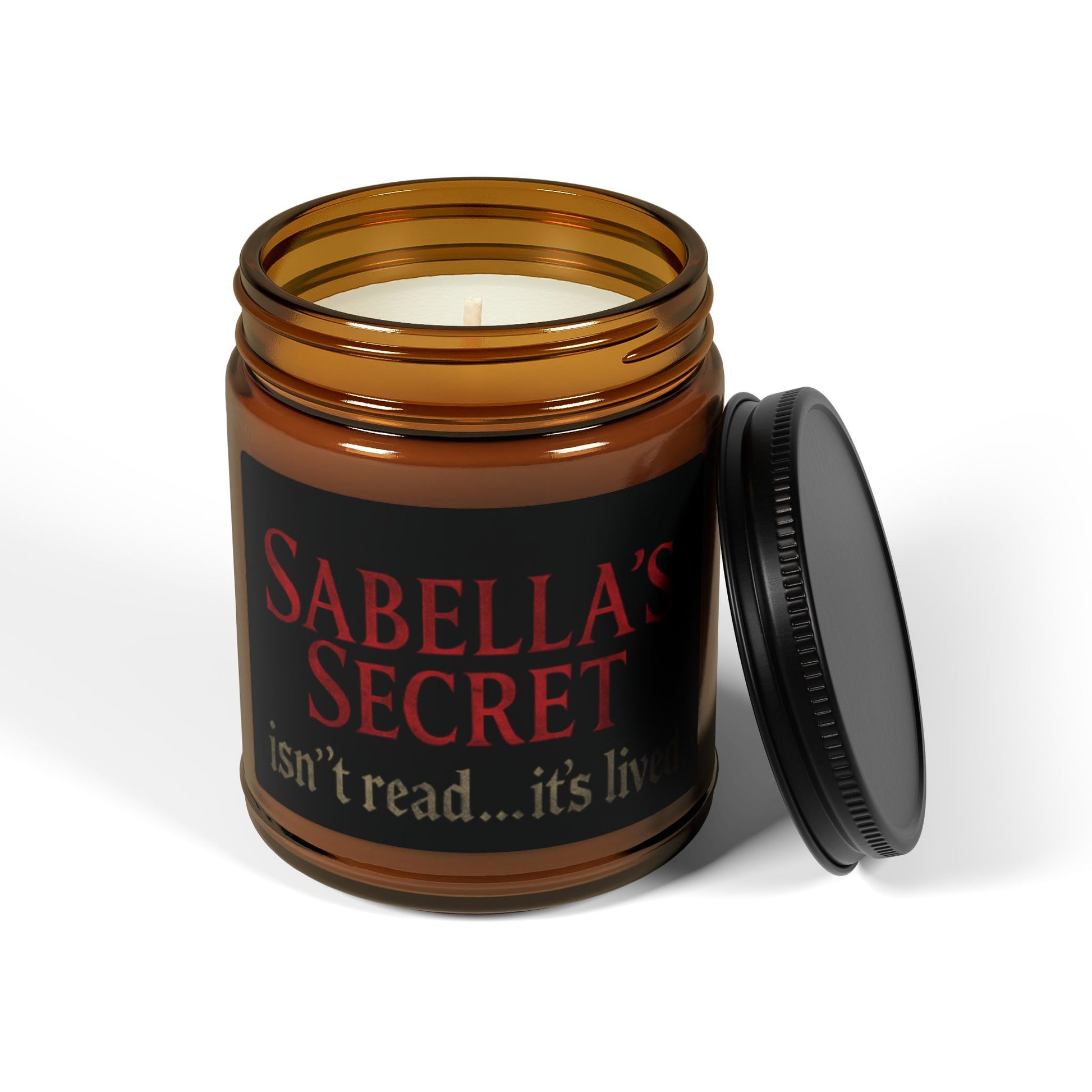 Candle in an amber jar with a black label featuring 'Sabella's Secret' on a white background